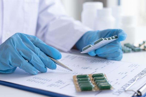 efeito placebo cientista com cartela de remedio na mão, uma caneta e um papel