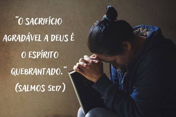 mulher ajoelhado orando com livro na mão