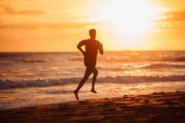 motivação homem correndo na praia