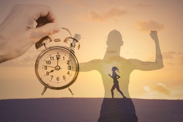 motivação uma mão segurança relógio, a sombra de uma mulher e outra mulher correndo com céu amarelado