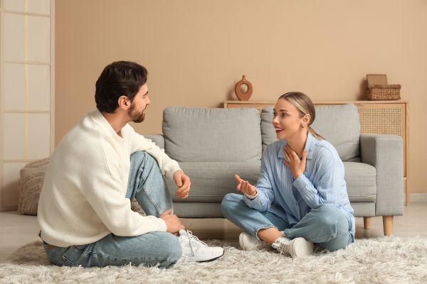 como ter relacionamento duradouro casal sentado no chão sorrindo representando como ter relacionamento duradouro