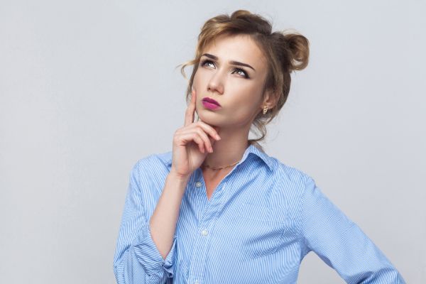 indecisão mulher com mão no queixo olhando pra cima