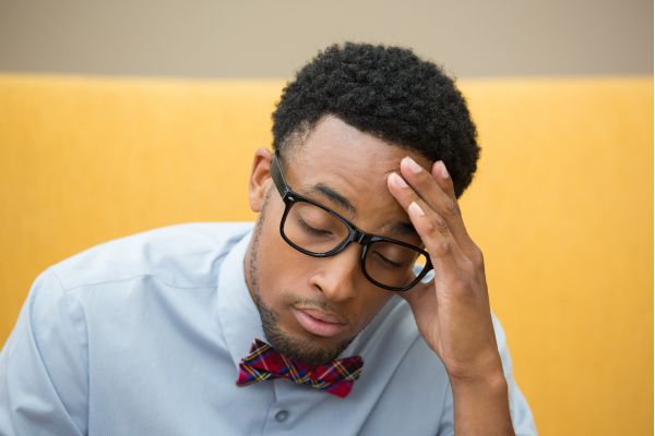 preocupação excessiva homem negro com óculos e olhos fechados com mão na testa preocupado