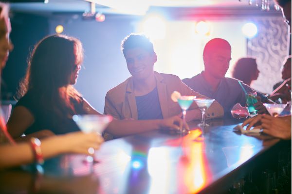 como conquistar mulhers difícieis uma mesa com drinks com homem e mulher conversando na balada