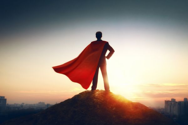 homem com capa vermelha do superman olhando a cidade