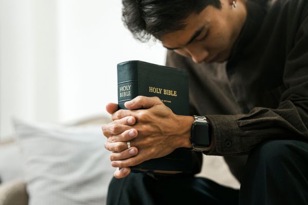 homem segurando a biblia representando conversando com deus