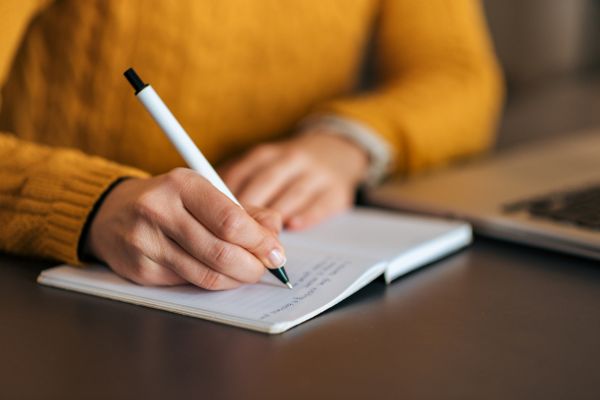 mulher com caneta e caderno
