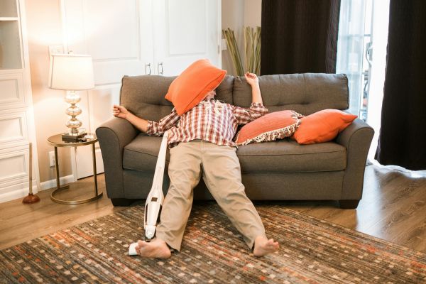 sabotador mental homem esparramado no sofa com almofada na cara