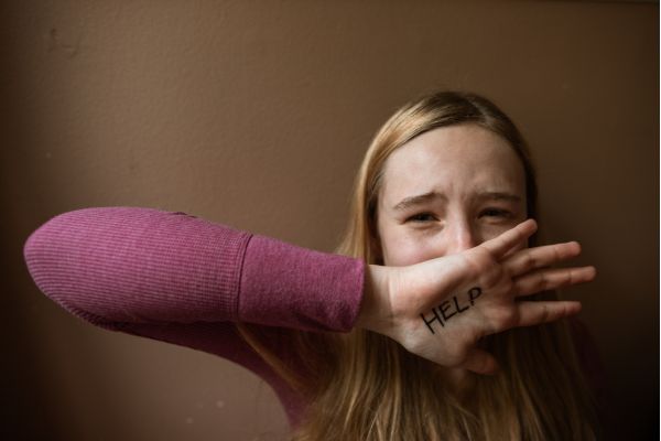 sabotadores mental garota chorando com a mão na cara escrito ajude em ingles