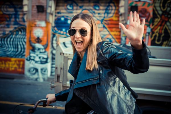 autenticidade - como vencer na vida garota de bicicleta com braço levantado sorrindo