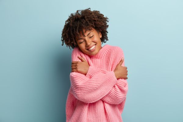 fundo azul com garota com blusa rosa se abraçando