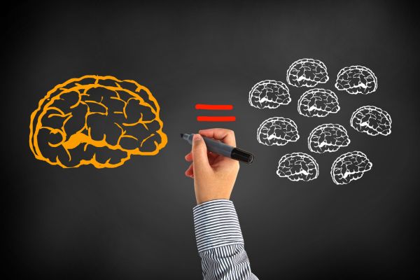 uma mão desenhando de cerebro igual monte de cerebros pequenos