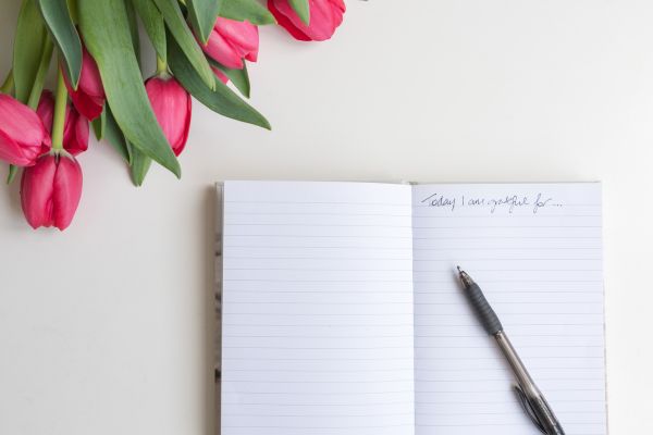 como praticar a gratidão caderno, caneta e flores
