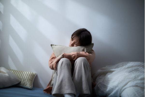 como superar a carencia afetiva mulher sentada abraçado no travesseiro