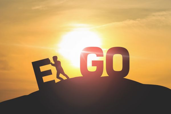 mecanismos de defesa do ego uma pessoa empurrando a palavra E do lado a palavra GO com sol no fundo