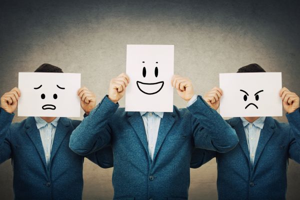 mudança e desenvolvimento pessoal 3 homens com papel no rosto representando uma emoção