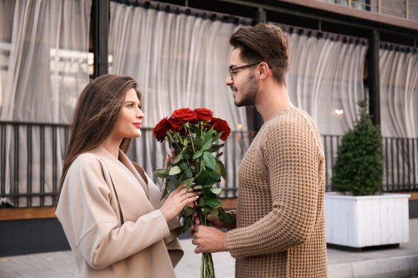 homem entregando flores para a mulher