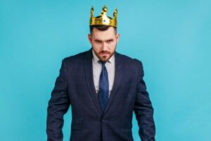 fundo azul com homem de terno e gravata com coroa de rei