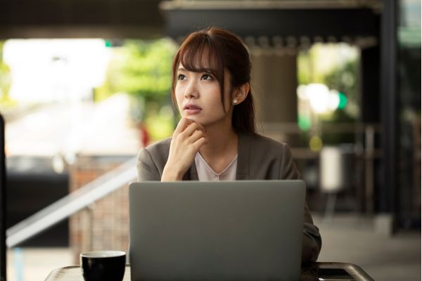 mindfulness - escritorio - mulher mulher sentada pensativa de frente para seu laptop