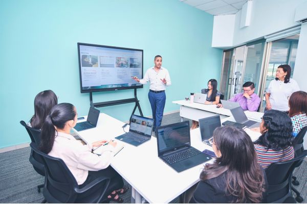 Equipe em reunião corporativa com comunicação aberta, promovendo saúde mental, escuta ativa e apoio psicológico no ambiente de trabalho.