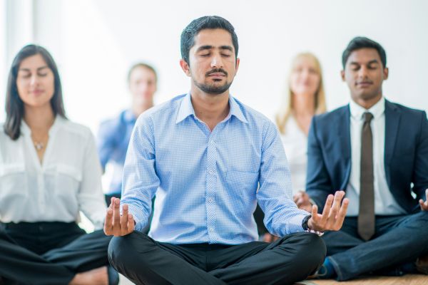 mindfulness ambiente corporativo grupo de pessoas sentando meditando no trabalho