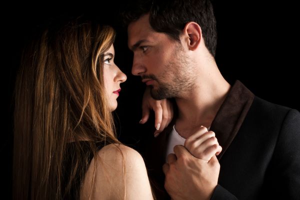 homem olhando para mulher segurando a mão dela e olhando nos olhos