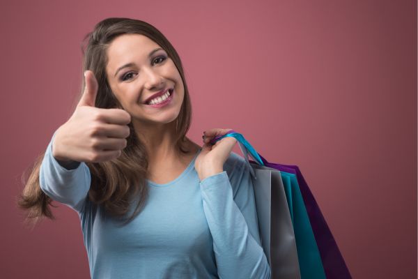 mulher com bolsa fazendo joia e sorrindo
