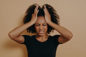 mulher negra com mão na cabeça