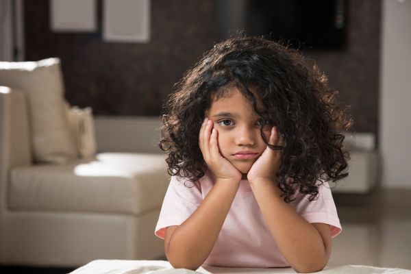 rejeição materna menina com mãos na bochecha representando insatisfação