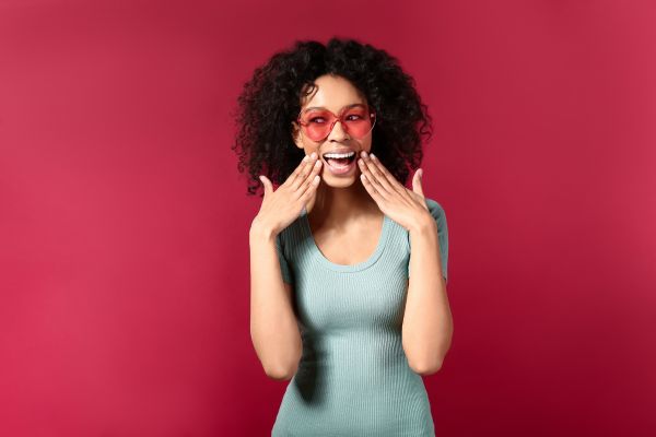 formação em psicologia positiva - ciência mulher sorrindo com olhos vermelhos e fundo vermelho