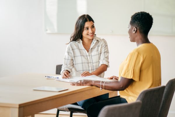 mercado de trabalho duas mulheres sentadas representando entrevista de emprego