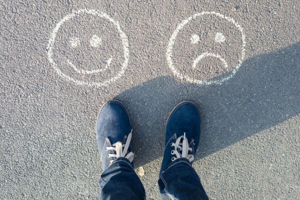 Ilustração simples mostrando a dualidade entre felicidade e infelicidade.