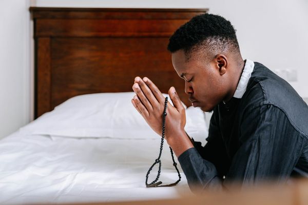 oração por intercessão homem com terço de joelhos na cama