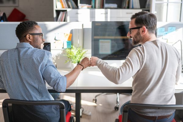 espiritualidade no cotidiano relacoes trabalho conexao Dois colegas cumprimentando-se no trabalho simbolizando espiritualidade aplicada ao cotidiano e às relações humanas.