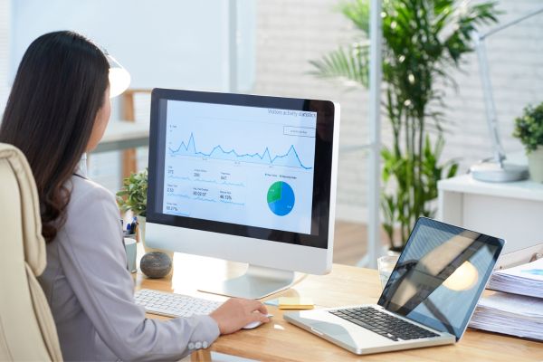 Pessoa analisando gráficos financeiros no computador representando prosperidade financeira e planejamento patrimonial