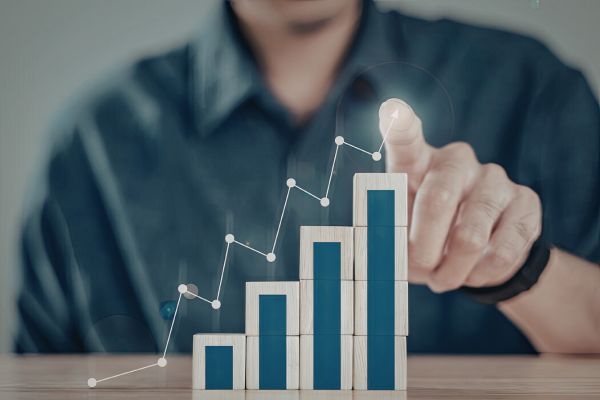 Pessoa impulsionando gráfico de crescimento ascendente representando transformação e evolução financeira consistente.