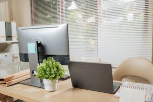 ambiente de trabalho minimalista com notebook, monitor e mesa organizada representando produtividade