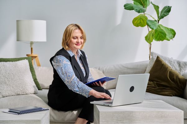 vida e proposito perspectiva psicologica Mulher analisando informações no laptop em ambiente tranquilo representando vida e propósito sob a perspectiva psicológica.