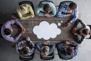 grupo de pessoas reunidas discutindo ideias representando pressão social e necessidade de agradar os outros