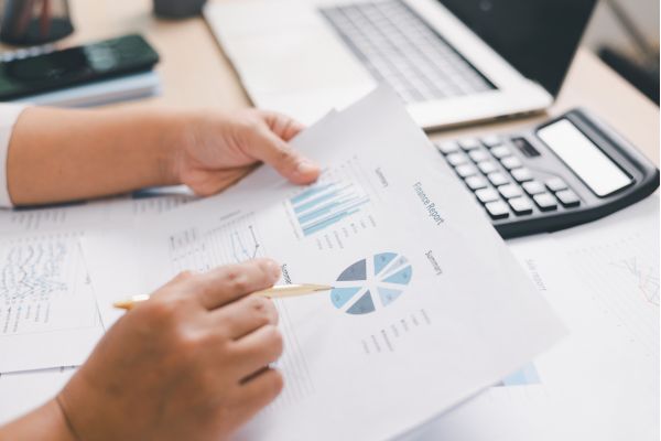 analise comportamento financeiro dados Pessoa analisando gráficos financeiros em relatórios,