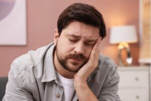 Homem com expressão de cansaço mental e falta de energia pela manhã