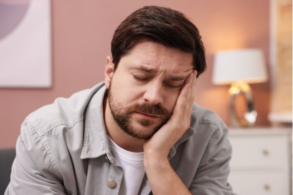 Homem com expressão de cansaço mental e falta de energia pela manhã