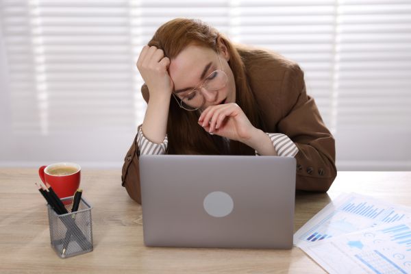 cansaço mental sono durante o dia Mulher com sono e cansaço mental trabalhando no laptop durante o dia