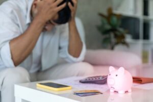 homem preocupado com dívidas olhando contas e cartão de crédito