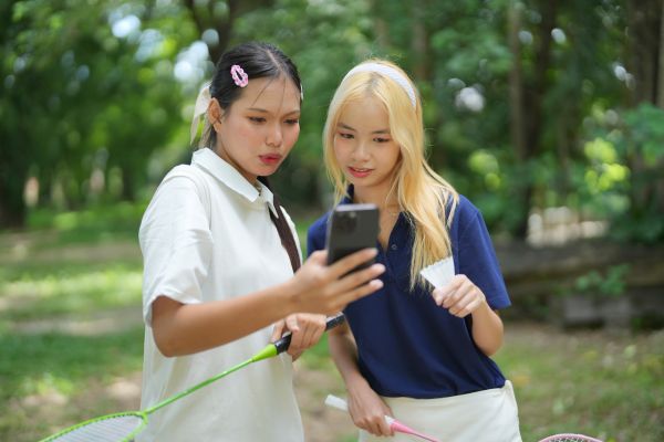 Duas jovens olhando celular representando comparação social nas redes sociais
