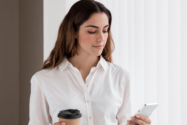 Mulher olhando o celular refletindo sobre comparar sua vida com a dos outros nas redes sociais