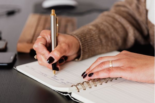 exercicio pratico napoleon hill Pessoa escrevendo metas em um caderno representando exercício prático de desenvolvimento pessoal inspirado em Napoleon Hill