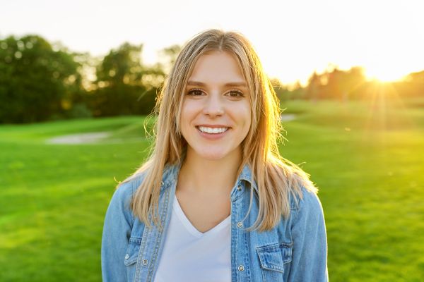 felicidade autoconfiança bem estar pessoal Mulher sorrindo ao ar livre representando felicidade, autoconfiança e bem-estar pessoal