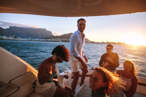 ficar rico investindo pouco estilo de vida luxo Grupo de amigos em um barco aproveitando a vida, representando o objetivo de ficar rico investindo pouco e conquistar liberdade financeira