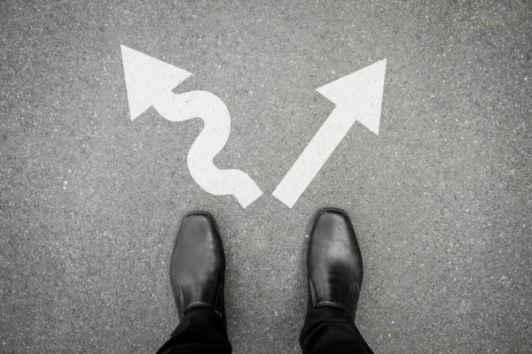 Pessoa diante de duas direções simbolizando o medo de tentar e tomar decisões